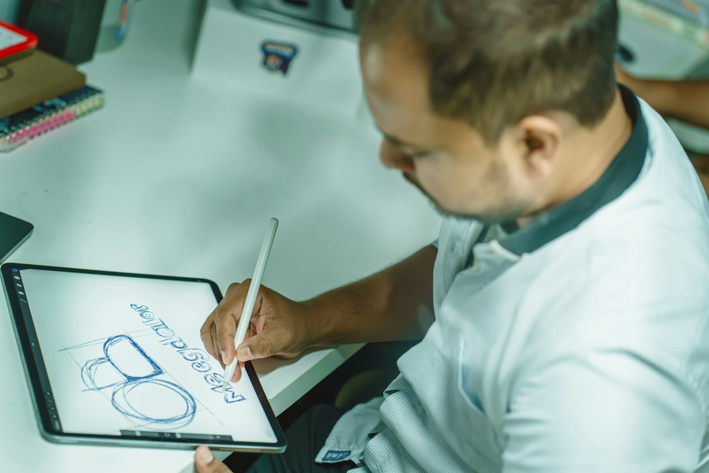 Illustrative designer sketching a visual concept on a digital tablet
