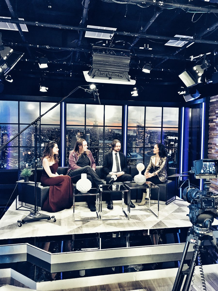 Behind the scenes of a TFT TV panel production, with cameras, studio lighting, and guests on set